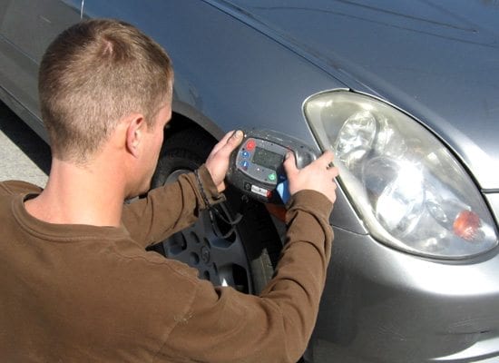 A man uses a device to diagnose a car